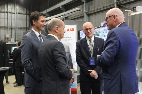 Prime Minister Justin Trudeau and German Chancellor Olaf Scholz discuss the importance of green hydrogen production to the two countries’ economic and energy futures. In turn, ABB Process Industries President Joachim Braun (2nd from R) and Hydrogen Optimized CEO Andrew Stuart (R) explain how ABB high-powered rectifiers support Hydrogen Optimized’s RuggedCell technology in using wind power to produce hydrogen at scale. The leaders met at the German-Canadian Atlantic Renewable Hydrogen Expo in Stephenville, Newfoundland Aug. 23. (CNW Group/Hydrogen Optimized Inc.)