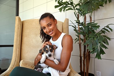 2022 Remember Me Thursday® Official Spokesperson Jasmine Tookes takes time to cuddle with Helen Woodward rescue pup Chance.