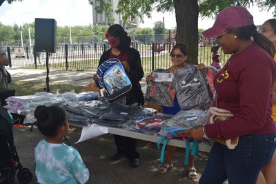 Jose de Diego Community Academy special education classroom assistants Francine Taylor (left), Maria Bucio, and Tosha Casey distribute backpacks provided by Katten to students at the Back-to-School BBQ in Chicago on August 19, 2022.