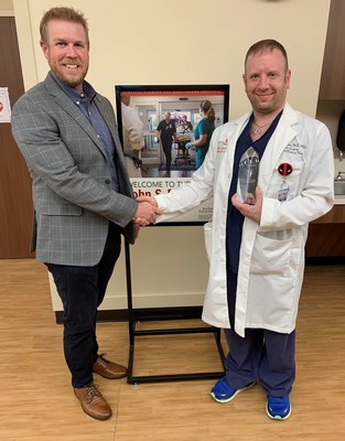 AlloSource Area Sales Manager, Chad Hartmann, presents Dr. Todd Huzar with the sixth annual Dr. Steven Gitelis Award in recognition for his contributions to helping patients heal through the gift of tissue donation.