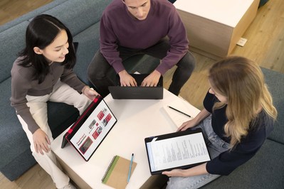 Three students using their Nokia PureBook Fold in the library working on a presentation