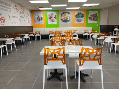 The cheerful, colorful dining room at the Shawarma Press Arlington franchise location features menu items and the company's core values on the walls.