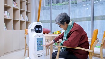 A resident at China Merchants Health Care in Shenzhen is interacting with the Companion Robot- Welli