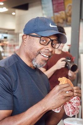 A hungry customer enjoys a Jollibee Chicken Sandwich and other mouth-watering options at the Sept. 2 grand opening of the global restaurant brand’s first-ever Philadelphia location. (Photo credit: Jollibee)