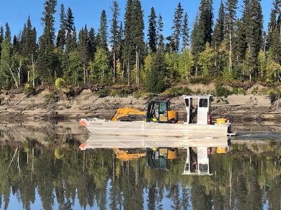 The barge crossing of the excavator across the Liard River (CNW Group/NorZinc Ltd.)