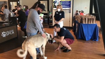 Les bénévoles de Hill, le Dr Omar Farias et le Dr Mag-Brett Angarano, aident à distribuer les sacs Hill's Pet Nutrition Goodie lors de l'événement d'adoption de la SPCA de Houston au cours du week-end à Clear The Shelters du 26 au 28 août 2022.