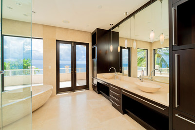 A sumptuous primary bath includes a handsome stone soaking tub, walk-in shower, and walk-out access to an oversized, oceanfront terrace. In total (including guest and caretaker's quarters) the property offers 9 bedrooms and 7.5 baths. Additional features at CaymanLuxuryAuction.com.