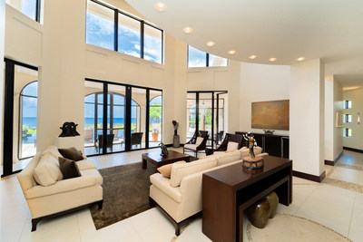 The property's grand salon features soaring ceilings that welcome ample natural light. Interiors were designed by internationally-renowned, luxury hotel designer Pam Anderson, while noted architects Arek Joseph and Wil Steward of Chalmers Gibbs Martin Joseph were also commissioned to create the living structures. Details at CaymanLuxuryAuction.com.