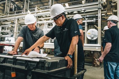 Infinium workers collaborating at a production facility.