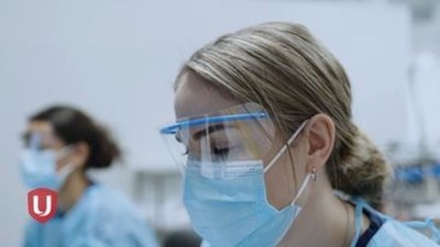 Lab tech wearing safety glasses and mask (CNW Group/Unifor)