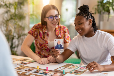 Two girls play HerStory and check out the Jane Goodall card.