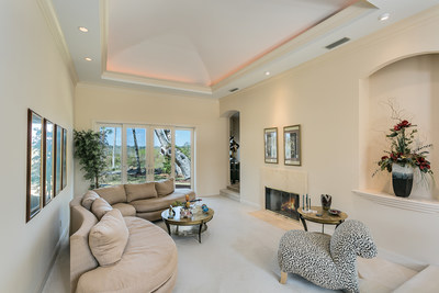 The main salon features lofted ceilings, a fireplace, built-in art displays and French doors opening to the rear patio and private backyard. PonteVedreBeachLuxuryAuction.com.