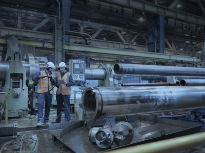 Engineers checking steel tubes in engineering factory