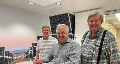 From left to right: Christian Gardner, Luigi Resta and Kem Gardner pose for a photo while Luigi signs the Green River Energy Center Power Purchase Agreement