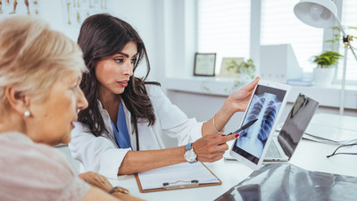 Patient and health care provider looking at lung X-ray.