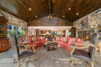 Pictured here is the main salon of the River House, one of Pecan Bluff's two residences. The home offers river views and sprawling outdoor living areas that include lounges, BBQs, and a fire pit with surround seating. More details at TexasLuxuryAuction.com.