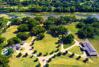 Known as Pecan Bluff, the property's three living structures are sited upon 20 gently rolling acres, with 2,000 ft of frontage along the Brazos River in Hill County, Texas. The Dallas Fort-Worth area is within an 80-min drive. Discover more at TexasLuxuryAuction.com.