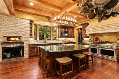 The warmth of the gourmet kitchen is provided both by its welcoming architecture and in the literal sense, thanks to a Wood Stone pizza oven. Fine finishes and a robust suite of top-of-the-line appliances make the kitchen a chef's delight. CaliforniaLuxuryAuction.com.