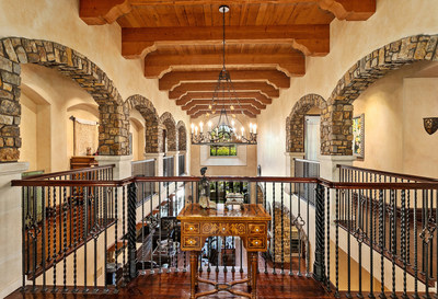 The residence's uppermost level features an open central area that looks out over the grand salon below. Beautiful stone archways and exposed beams help to augment the grandeur of the soaring ceilings. CaliforniaLuxuryAuction.com.