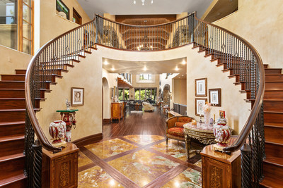 A lovely foyer with soaring ceilings and dual staircases creates a dramatic entry. Reclaimed woods, fine marble and rare stone were used extensively throughout the home. Three living levels allow for ample space for larger families or for entertaining on a grand scale. Discover more at CaliforniaLuxuryAuction.com.