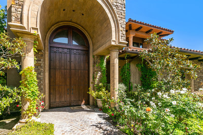 A soaring, custom door and stone archway create a regal ambiance upon arrival. The home is located within the private and gated community of Rancho Del Mar, a development of only 27 luxury homes. The enclave is adjacent to Lomas Santa Fe Country Club and within a 5-min drive of Solana Beach. CaliforniaLuxuryAuction.com.