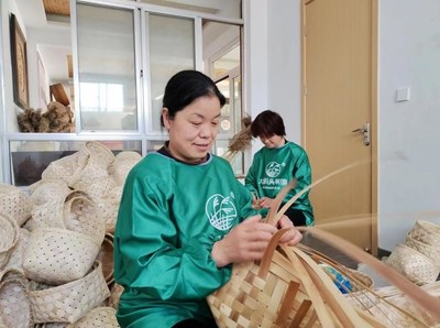 Xu Zunxia, an inheritor of the cultural heritage of reed crafts, working with others on reed products