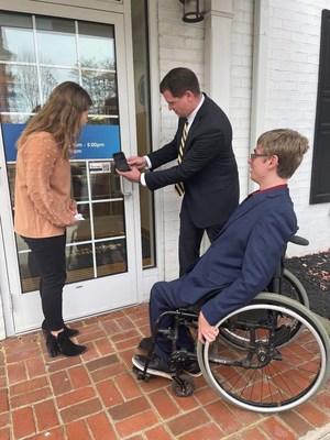 L to R: Branch Manager Robin Bedinger affixes the Visitable advocate certification sticker while Joe Jamison, founder of Visitable, demonstrates the QR code feature. Corey Paradis joined the Visitable team this year.