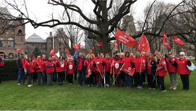 Unifor delegation in front of the legistlative building wearing red Unifor shirts waving our flags (CNW Group/Unifor)