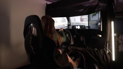 Teen driver in driving simulator navigating the simulated roadway. On dashboard, target symbol appears that they will need to search for on a visual display situated on a simulated center console. Source: CIncinnati Children's