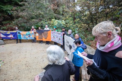 Gert McMullin, mother of the AIDS Memorial Quilt, leads a community reading of names in the Circle of Friends at the National AIDS Memorial Grove on World AIDS Day.  The names being read are newly engraved this year within the memorial and also of newly created panels being added to the AIDS Quilt.  Credit:  Onyx and Ash Photography