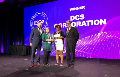 Employee-owners Amy Kirby and Janice Booker (center) accept the Annual Award for Communications Excellence (AACE) on behalf of DCS Corporation. Also pictured are The ESOP Association (TEA) representatives Derrick Vick and Steve Earle. Photograph courtesy of TEA.