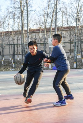 Teenagers take to an outdoor court for a game of basketball in Beijing on December 3 (WEI YAO) (PRNewsfoto/Beijing Review)