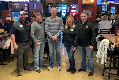 Celebrating the opening of the first Anchor Bar world-famous Buffalo chicken wing franchise in Illinois in the Village of Oswego are Jonathan Henderson, Matt Kellogg, Troy Parlier, and Anchor bar owners Laura and Samm Dimech.