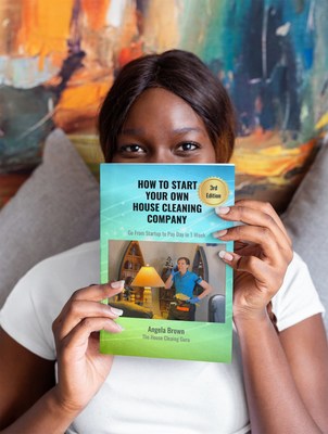 How to Start Your Own House Cleaning Company Book by Angela Brown, Woman holds up book.