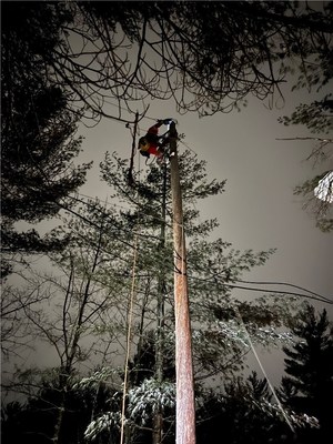 A Hydro One line maintainer climbs a pole to complete repairs in the Perth area. (CNW Group/Hydro One Inc.)
