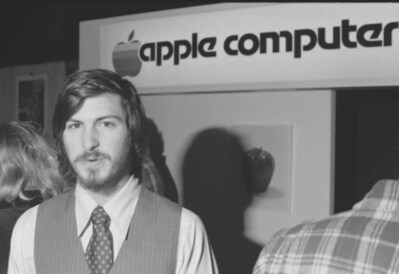 Steve Jobs standing beneath the first Apple Computer trade sign at a ca. 1976 trade show. The sign was later used for year to identify the company's offices in Cupertino, Ca. To be sold at auction on Jan. 27, 2023 by Alexander Historical Auctions, Chesapeake City, Md.