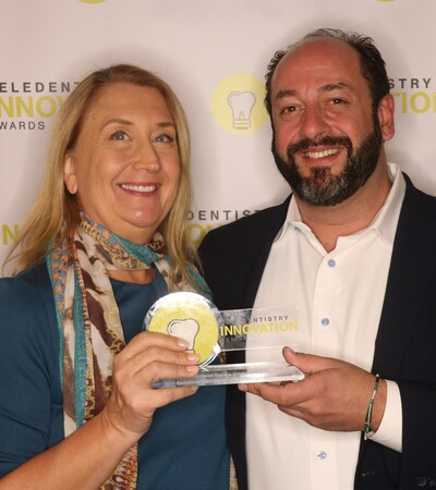 Dr. Jennifer Boyce, Associate Director of Clinical Affairs at the Fones School of Dental Hygiene, accepts the 2022 Tellie Award from MouthWatch founder and CEO, Brant Herman, for her efforts leading the school's teledentistry and mobile dentistry community outreach efforts.