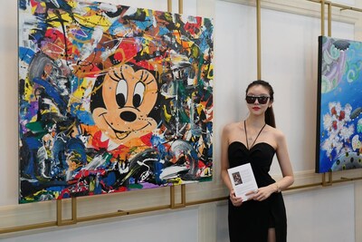 Artist Wang Yihan poses with a painting from her The Rich and Noble Elf) series, titled Childhood.