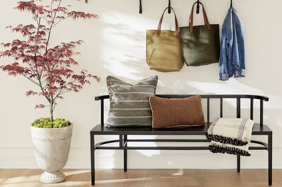 Curved wood benches and organic throws and pillows fit the 2023 home in Ballard Designs trending style.