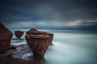 Jeremy Klager the Missing Teapot - A long exposure of the waves crashing against the red rocks of Prince Edward Island lends a feeling of timelessness to this shot of the island's famous "Teacup Rock," which was washed away by Hurricane Fiona a few weeks after the photo was taken. This image is the winner in the "Epic Landscapes" category of Canadian Geographic's 2022 Canadian Photos of the Year competition. Photo © Jeremy Klager. (CNW Group/Royal Canadian Geographical Society)