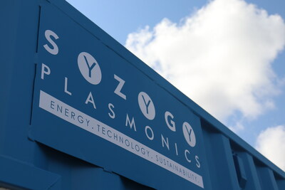 Syzygy Plasmonics logo on an electrified photocatalytic reactor container.