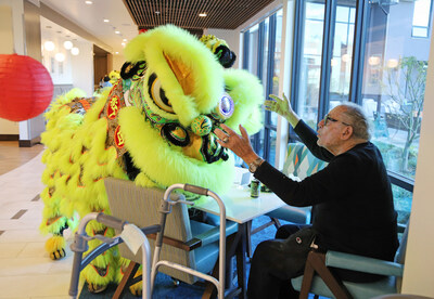 Stu Span, resident at Frank Residences in San Francisco, gets a one-of-a-kind hello from Lunar New Year performers during the festival celebrations at the community.