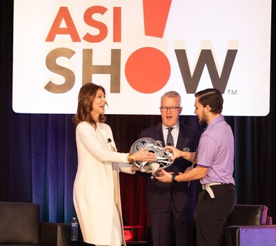 Dallas Cowboys exec and keynote speaker Charlotte Jones awards 2 Cowboys tickets to a lucky winner at the ASI Fort Worth trade show as ASI CEO Tim Andrews looks on.
