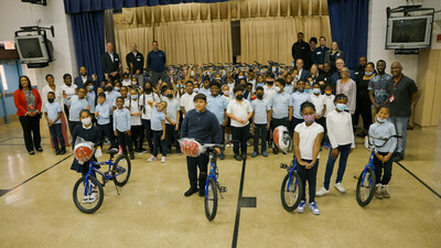 Bikes for Kids Foundation President, Robert Krumroy, stands with employees of Passport Auto Group and students and staff of Panorama Elementary during a school assembly.