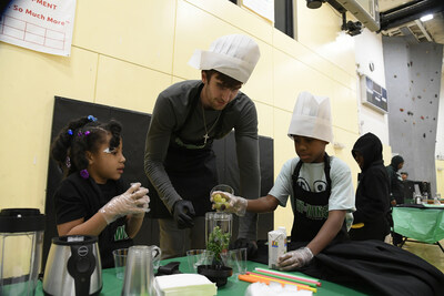 Celtics center Luke Kornet makes smoothies with Fit to Win participants during nutrition education event.