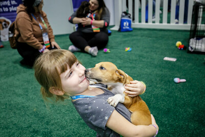 Puppy Love: A child holds a puppy at the Puppy Playground during VMX 2023