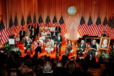 RBG Award Committees, Nancy Pelosi, Honoree Diane von Furstenberg, David Rubensten, Julie Opperman, and Sylvester Stallone honoring Justice Ruth Bader Ginsburg by draping pink boxing gloves over her portrait in a “Champ to Champ” moment. (RBG Award)