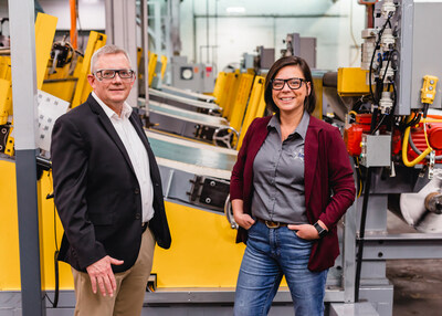 Paul Menosky, chief operating officer, Loc Performance, and Krista Larmore, plant manager, Loc Performance St. Marys, in front of the new equipment which will expand capacity for Loc Performance's Trackman products to meet increasing customer demand.