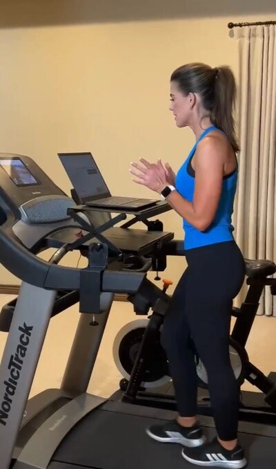 WALK-i-TASK customer, Angie W, is walking during a virtual meeting with her height adjustable treadmill desk attachment.