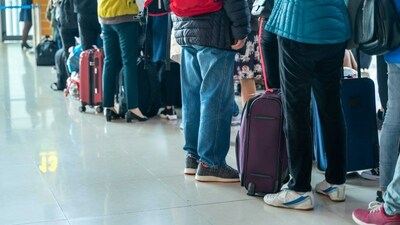 People standing in line with luggage at the airport check in. (CNW Group/Unifor)